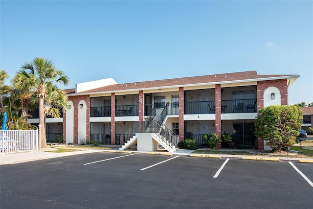 1531 Placida Rd Unit 4-103, Englewood, FL 34223 - view of building exterior featuring stairs, uncovered parking, and fence