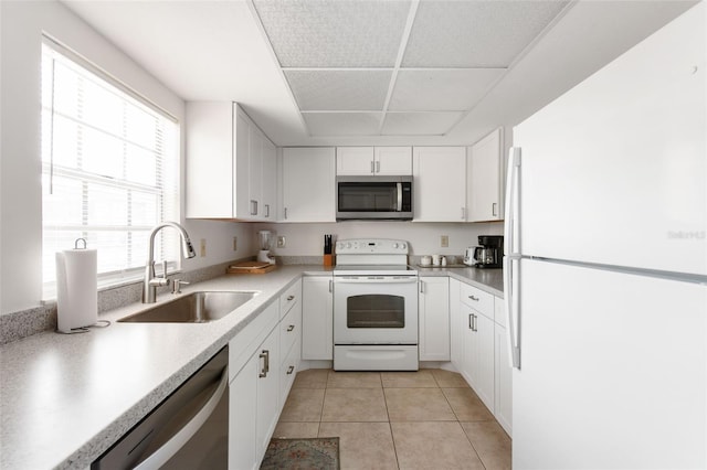 1531 Placida Rd Unit 4-103, Englewood, FL 34223 - kitchen featuring appliances with stainless steel finishes, a sink, white cabinets, light countertops, and light tile patterned floors