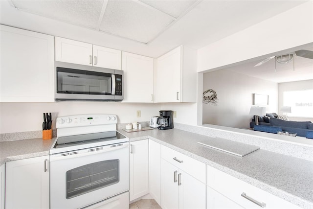 1531 Placida Rd Unit 4-103, Englewood, FL 34223 - kitchen featuring stainless steel microwave, electric stove, white cabinetry, and open floor plan