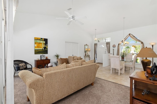 living area with a ceiling fan, high vaulted ceiling, visible vents, and light carpet