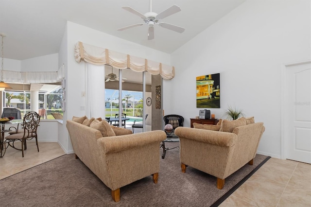tiled living room featuring baseboards, a ceiling fan, and lofted ceiling