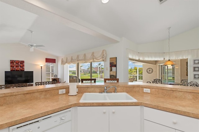 kitchen with a sink, light countertops, vaulted ceiling, and dishwasher