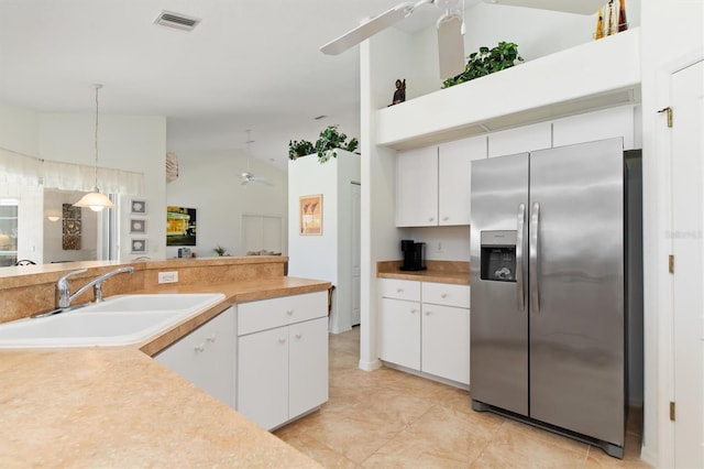 kitchen with a ceiling fan, visible vents, vaulted ceiling, a sink, and stainless steel fridge with ice dispenser