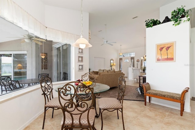 dining room with ceiling fan and high vaulted ceiling