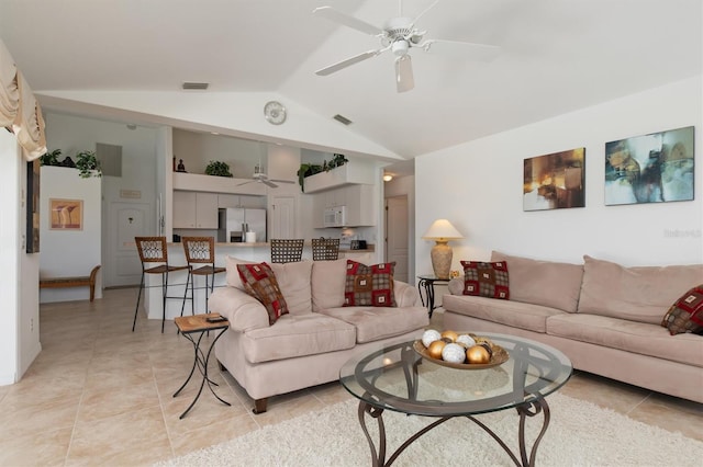 living room with a ceiling fan, vaulted ceiling, light tile patterned floors, and visible vents