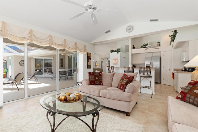 living area with a ceiling fan, visible vents, light tile patterned flooring, and vaulted ceiling