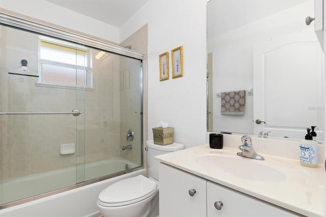 bathroom with vanity, bath / shower combo with glass door, and toilet