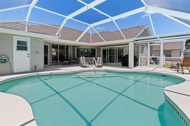 pool with glass enclosure and a patio