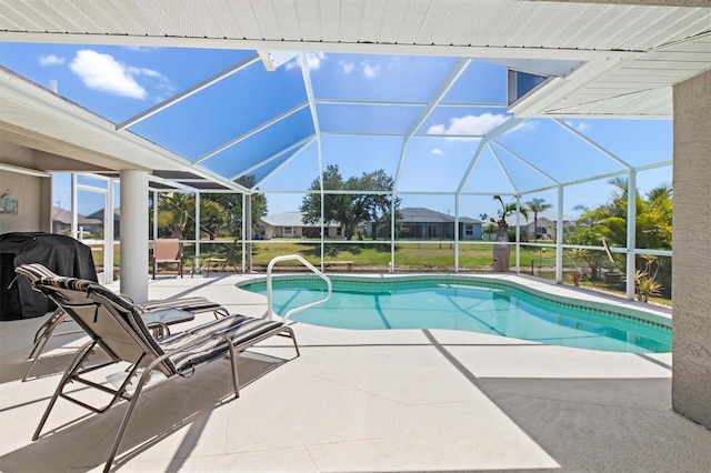 outdoor pool with grilling area, a patio, and glass enclosure