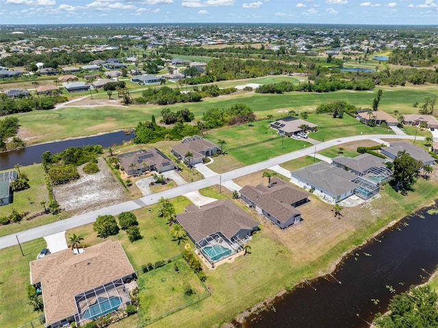 drone / aerial view with a water view, view of golf course, and a residential view