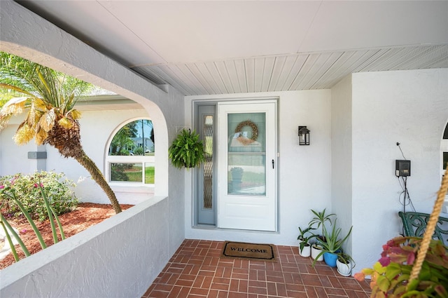 doorway to property featuring stucco siding
