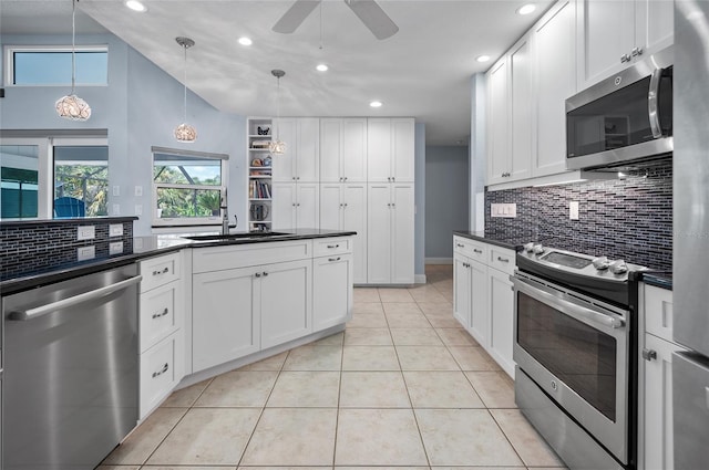 kitchen with dark countertops, appliances with stainless steel finishes, decorative backsplash, and a ceiling fan