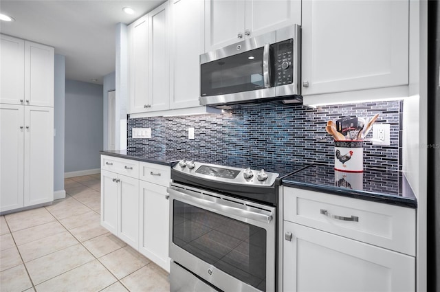 kitchen with white cabinetry, dark countertops, appliances with stainless steel finishes, and light tile patterned flooring