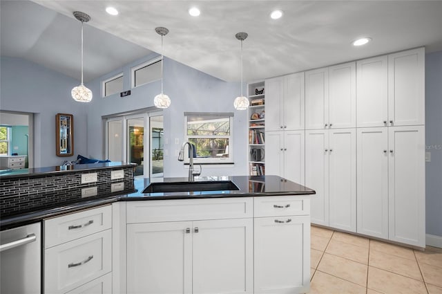 kitchen featuring dark countertops, plenty of natural light, lofted ceiling, and a sink