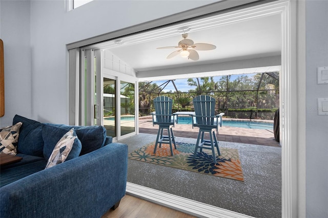 living area with a sunroom, ceiling fan, and wood finished floors