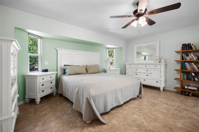 bedroom featuring multiple windows, light tile patterned flooring, and ceiling fan