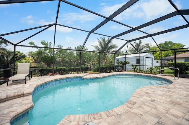 outdoor pool featuring a storage unit, a patio area, glass enclosure, and an outbuilding