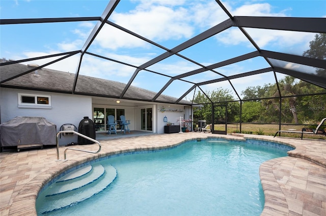 outdoor pool featuring grilling area, a lanai, and a patio