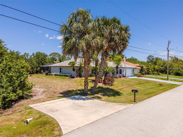 view of front of house featuring a front lawn, driveway, and a garage