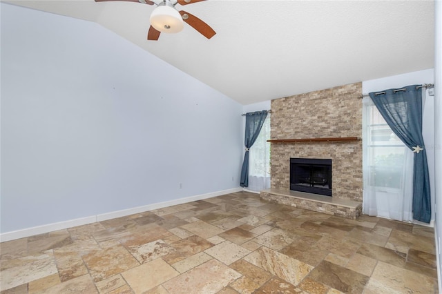 1155 Osceola Blvd, Englewood, FL 34223 - unfurnished living room featuring a ceiling fan, a fireplace, stone tile floors, baseboards, and lofted ceiling