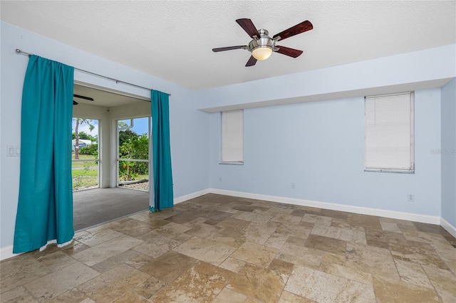 1155 Osceola Blvd, Englewood, FL 34223 - spare room featuring baseboards, a textured ceiling, stone tile floors, and a ceiling fan