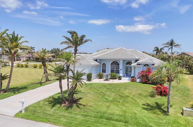11 Amberjack Ln, Placida, FL 33946 - mediterranean / spanish home featuring driveway, a tile roof, a front yard, a garage, and stucco siding