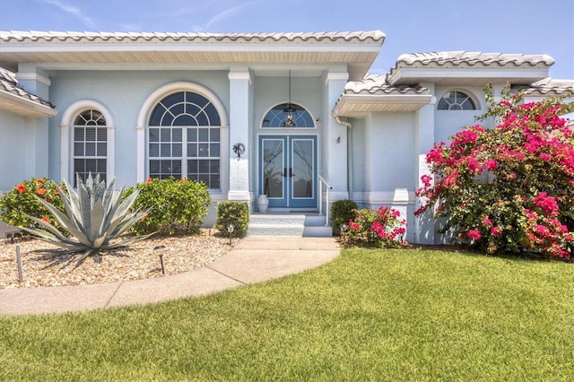 11 Amberjack Ln, Placida, FL 33946 - property entrance with stucco siding, a yard, french doors, and a tile roof