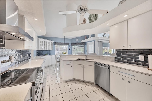 11 Amberjack Ln, Placida, FL 33946 - kitchen featuring wall chimney range hood, backsplash, light tile patterned floors, a sink, and stainless steel appliances