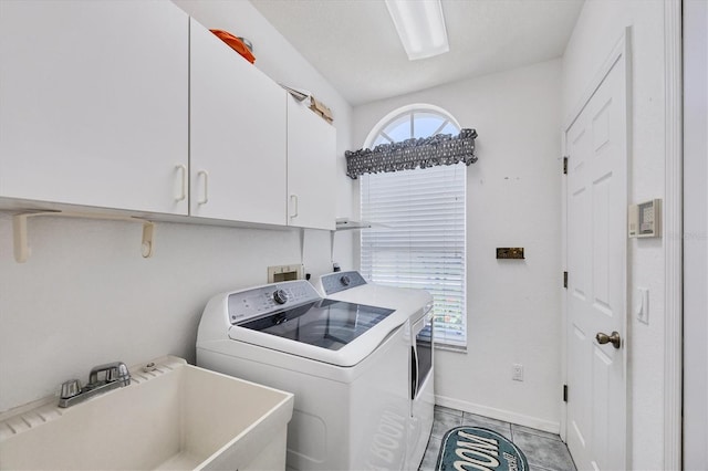 11 Amberjack Ln, Placida, FL 33946 - washroom featuring washer and dryer, light tile patterned flooring, cabinet space, a sink, and baseboards