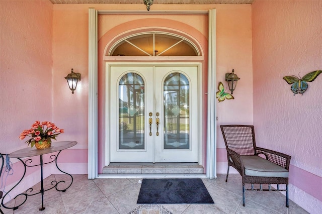 view of exterior entry with french doors and stucco siding