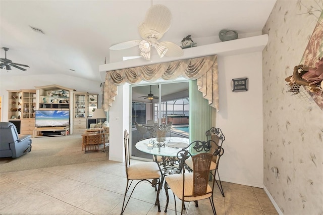 dining area with ceiling fan, visible vents, light tile patterned floors, lofted ceiling, and wallpapered walls