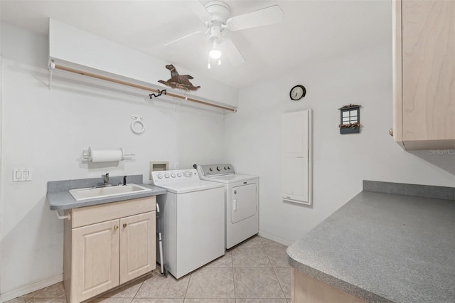 clothes washing area featuring a ceiling fan, washing machine and dryer, light tile patterned flooring, baseboards, and a sink
