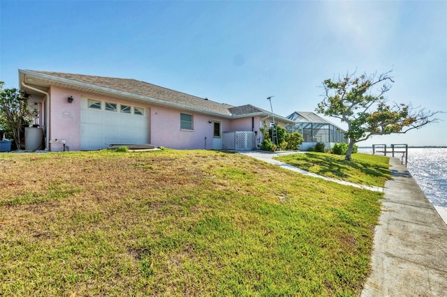 single story home featuring an attached garage, a front yard, and stucco siding