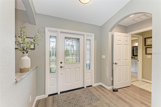 9211 Koma St, Port Charlotte, FL 33981 - foyer with visible vents, wood finished floors, baseboards, and arched walkways