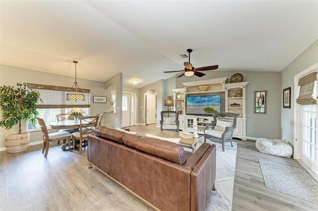 9211 Koma St, Port Charlotte, FL 33981 - living area with lofted ceiling, ceiling fan, light wood-style flooring, arched walkways, and baseboards