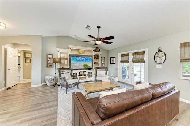 9211 Koma St, Port Charlotte, FL 33981 - living room featuring visible vents, vaulted ceiling, ceiling fan, light wood-style flooring, and arched walkways