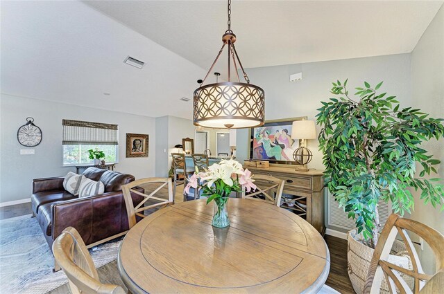 9211 Koma St, Port Charlotte, FL 33981 - dining area with baseboards, lofted ceiling, visible vents, and wood finished floors