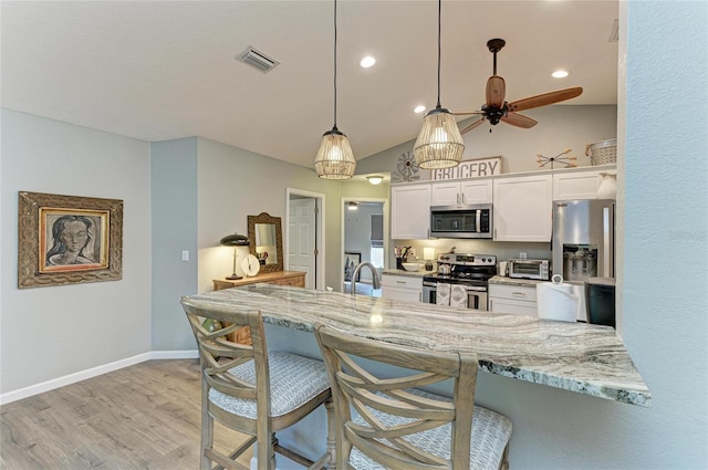 9211 Koma St, Port Charlotte, FL 33981 - kitchen with a breakfast bar, white cabinets, visible vents, and appliances with stainless steel finishes