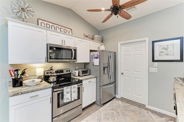 9211 Koma St, Port Charlotte, FL 33981 - kitchen featuring light wood finished floors, a ceiling fan, white cabinetry, appliances with stainless steel finishes, and lofted ceiling