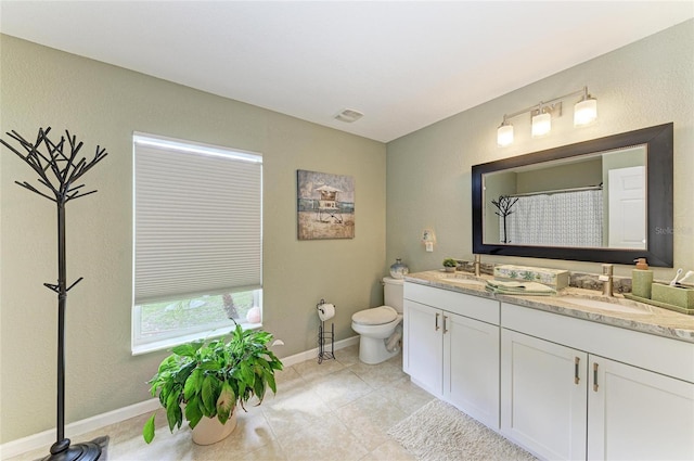 9211 Koma St, Port Charlotte, FL 33981 - bathroom featuring toilet, baseboards, double vanity, and a sink