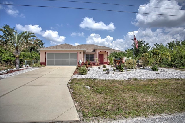 view of front of house with an attached garage, stucco siding, and driveway