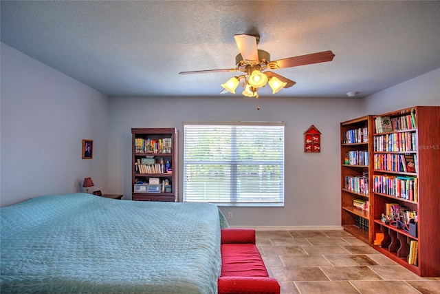 bedroom with a textured ceiling, baseboards, and a ceiling fan
