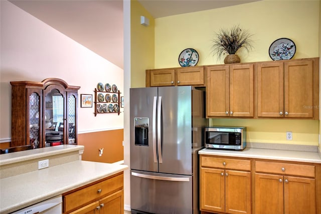 kitchen featuring brown cabinetry, stainless steel appliances, and light countertops