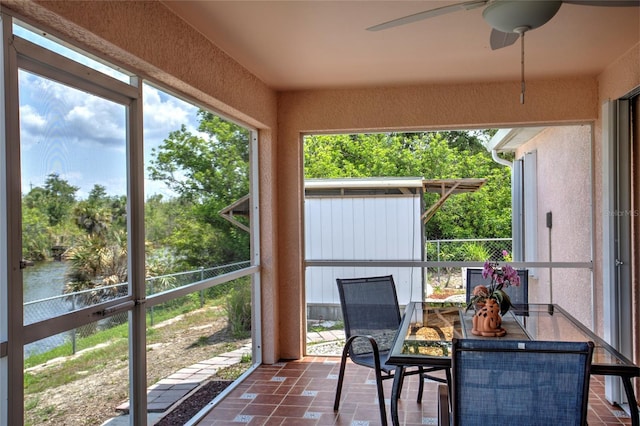sunroom / solarium featuring outdoor dining space and ceiling fan