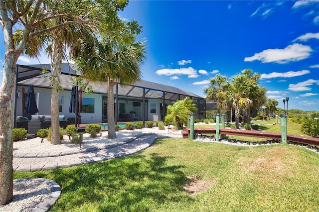 15176 Spanish Point Dr, Port Charlotte, FL 33981 - back of property with a yard, glass enclosure, a patio, and an outdoor hangout area