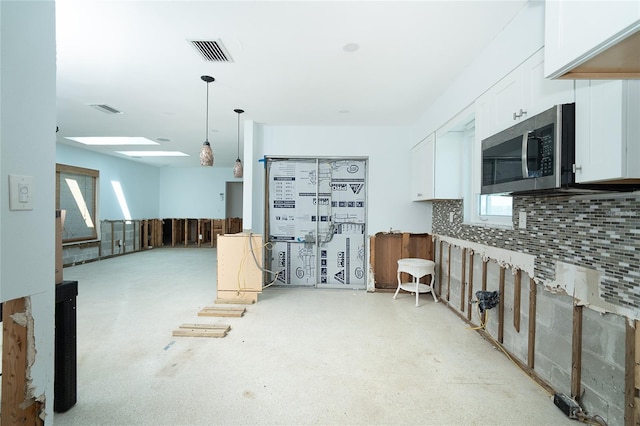 4093 Pelican Shores Cir, Englewood, FL 34223 - kitchen featuring stainless steel microwave, white cabinetry, backsplash, and plenty of natural light