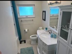 4093 Pelican Shores Cir, Englewood, FL 34223 - bathroom with toilet, vanity, a shower with shower curtain, and baseboards