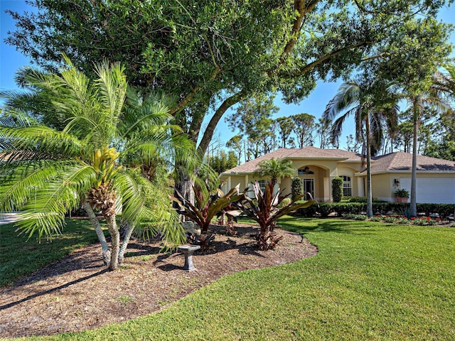 237 Rotonda Blvd E, Rotonda West, FL 33947 - view of front facade featuring a front lawn, stucco siding, and a garage