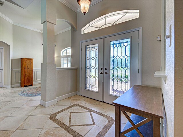 237 Rotonda Blvd E, Rotonda West, FL 33947 - tiled foyer featuring crown molding, french doors, arched walkways, decorative columns, and inlaid floor details
