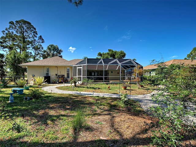 237 Rotonda Blvd E, Rotonda West, FL 33947 - rear view of property with glass enclosure, stucco siding, and a lawn
